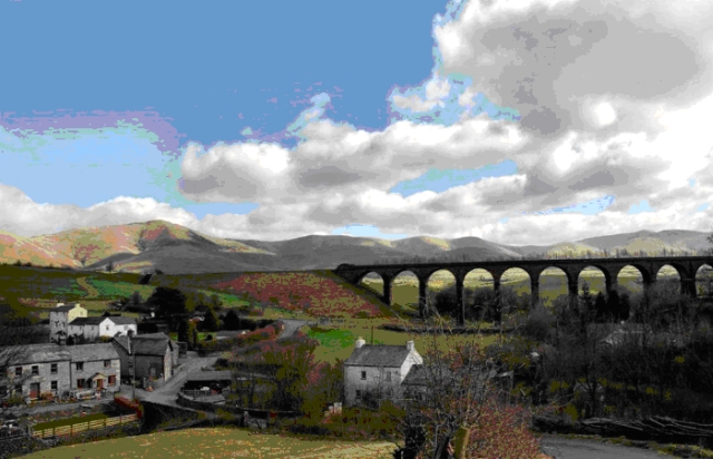 long arched railway bridge crossing a rural valley with hiss in the background